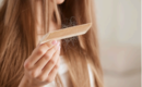 Woman experiencing hair loss brushing tangled strands